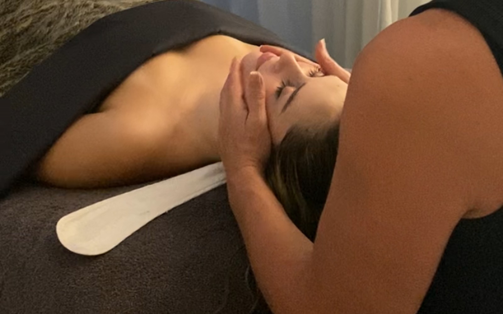 Nicole performing a signature facial treatment